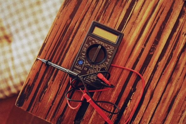 Close-up of a digital multimeter on a wooden table, perfect for technology or electronics-themed imagery.