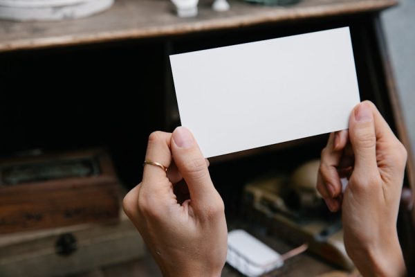 A blank rectangular card is held by hands, offering copy space for text or design.