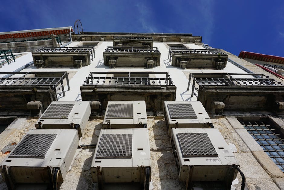 A upward view of a building facade with air conditioners and balconies in Porto.