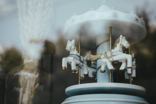 Close-up of a vintage carousel with horses reflecting softly in glass.