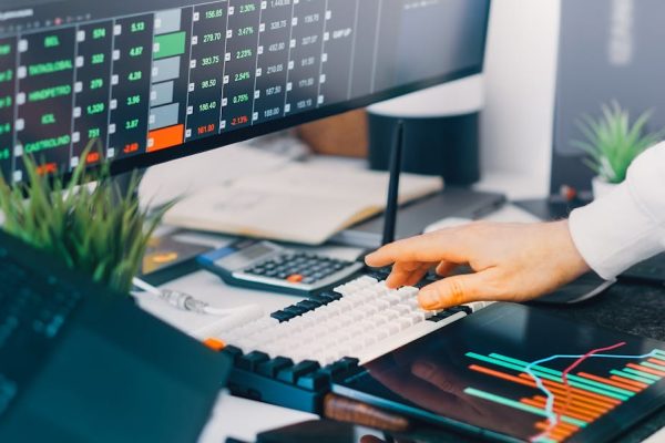 Professional workspace with trading charts and market data on screens, ideal for finance and investment contexts.