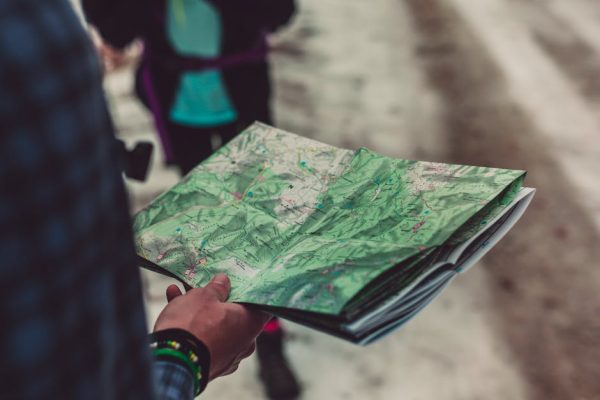 A close-up of a person holding a detailed route map outdoors, ideal for travel and exploration themes.
