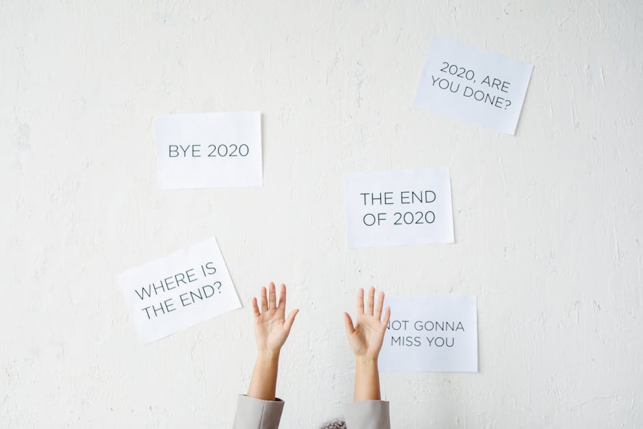 Hands reach up towards motivational text on a wall, saying goodbye to 2020.
