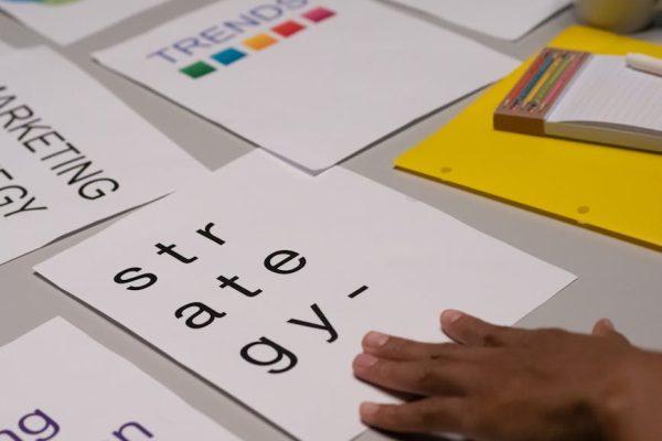 Close-up of marketing strategy notes and colorful trends sheet on a table for planning session.