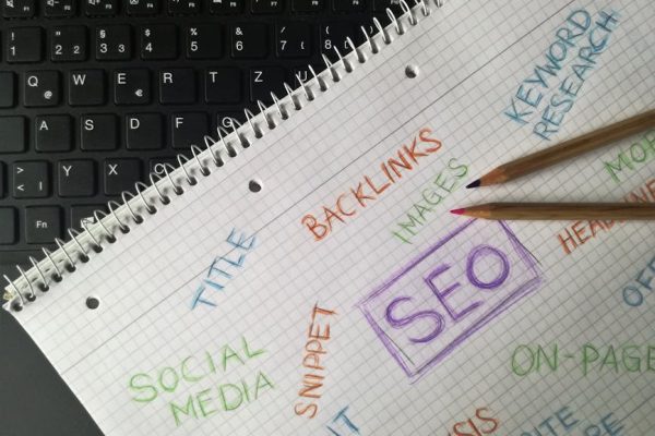 Close-up of notebook with SEO terms and keywords, highlighting digital marketing strategy.