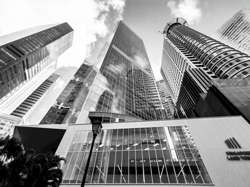 Dramatic black and white capture of towering skyscrapers in Singapore's CBD, emphasizing modern architecture.