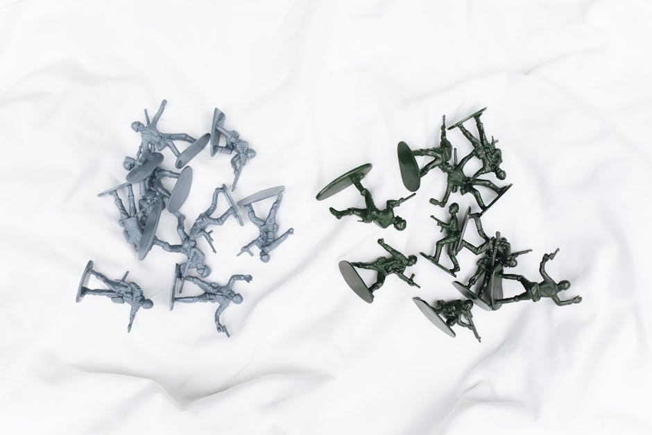 Colorful army toy figures arranged on a white cloth in aerial view.