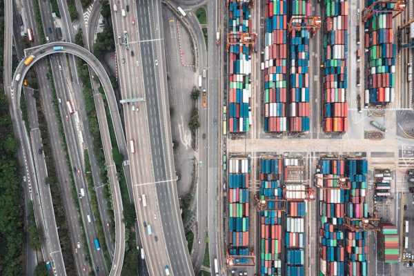 Aerial shot of Hong Kong's shipping containers and highway interchange showcasing urban logistics.