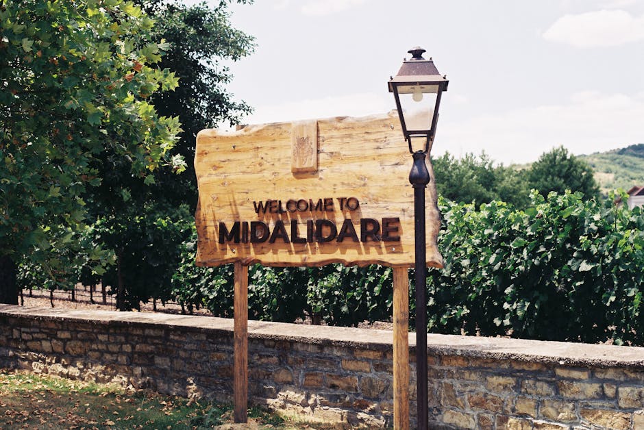 Welcome sign at Midalidare Vineyard with lush greenery background.