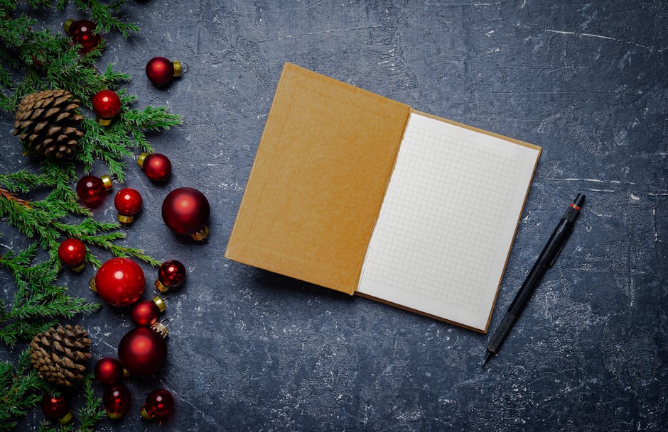 Open notebook with Christmas decorations on a concrete surface.
