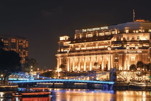 Stunning nighttime view of The Fullerton Hotel in Singapore, beautifully illuminated along the waterfront.
