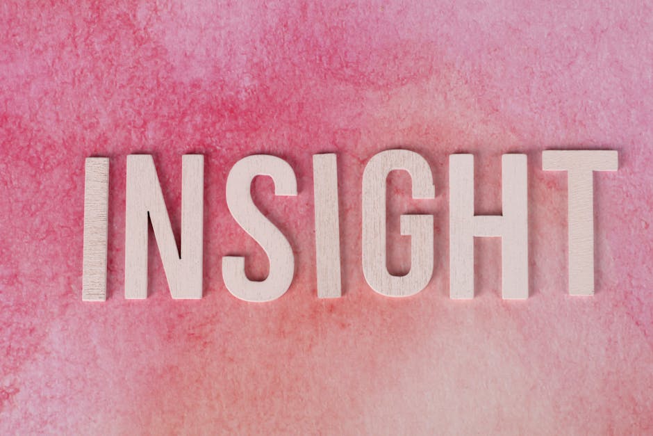 Wooden letters spelling INSIGHT on a pink watercolor background.