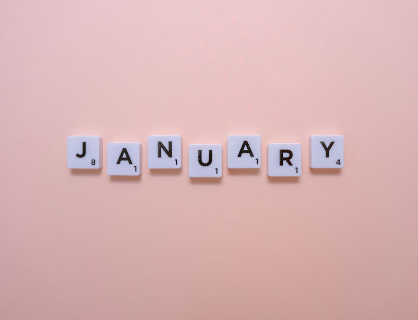 Scrabble-style tiles spell 'January' on a pastel peach background, evoking a fresh start.