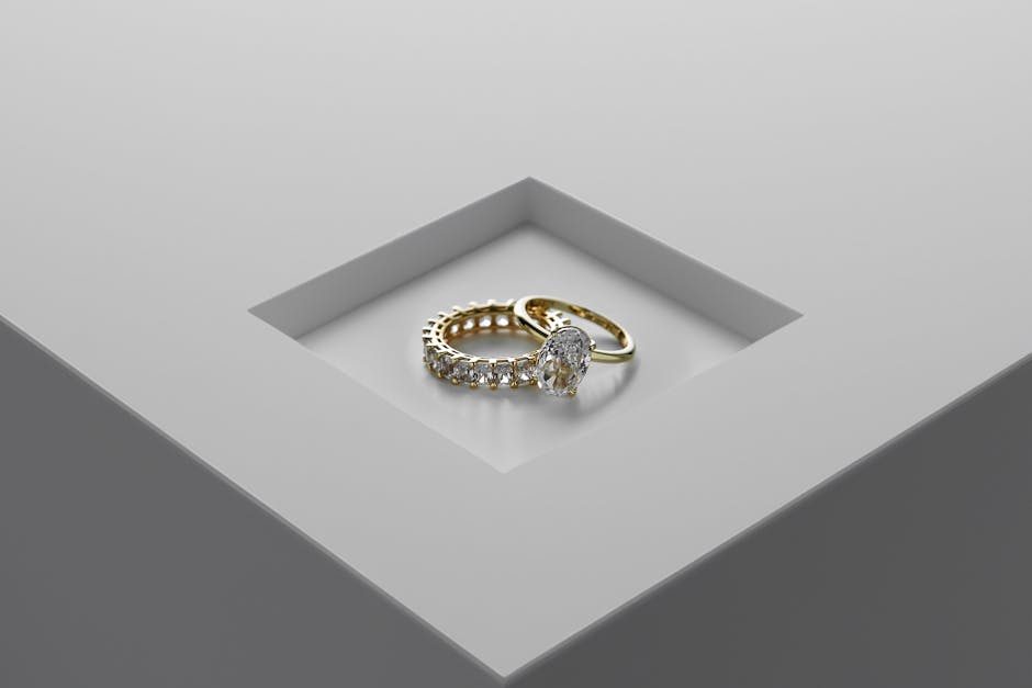 A close-up of exquisite gold and diamond rings set on a minimalist surface.