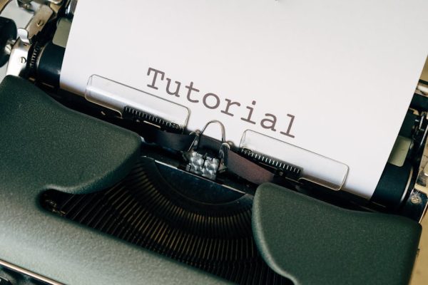 Close-up shot of a vintage typewriter with the word 'Tutorial' typed on paper.