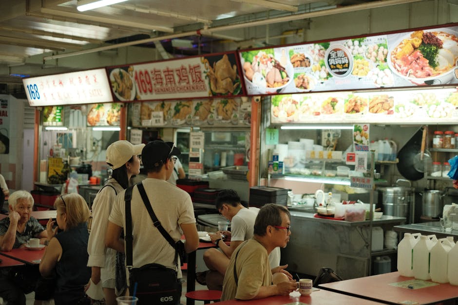 A vibrant scene capturing diners at a Singaporean hawker center enjoying local cuisine.