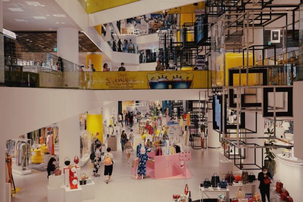 Vibrant mall filled with shoppers, contemporary decor, and stylish fashion outlets.