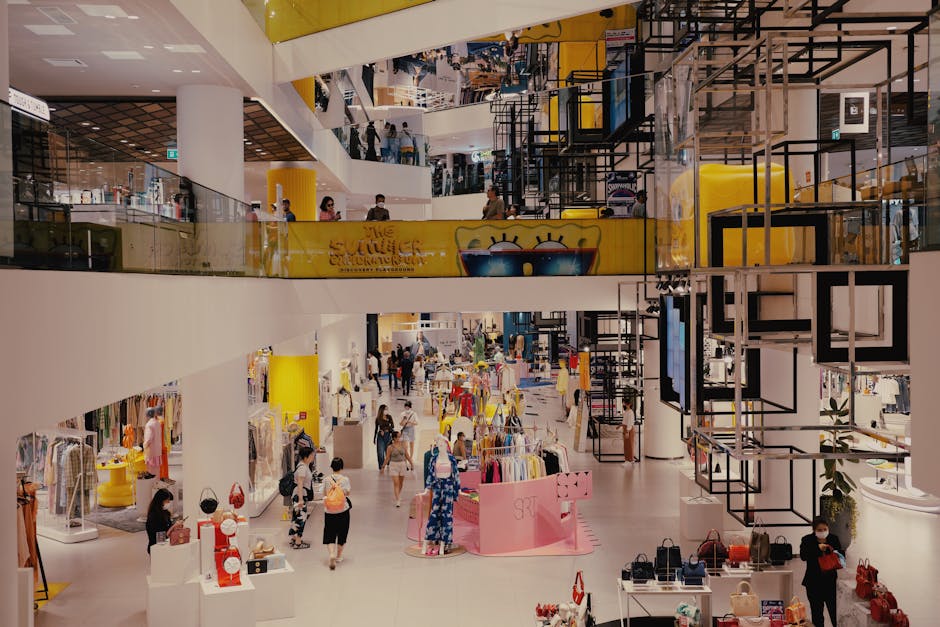 Vibrant mall filled with shoppers, contemporary decor, and stylish fashion outlets.
