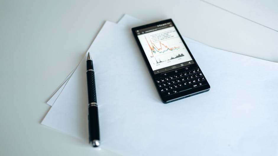 Smartphone displaying graphs on paper with a pen, perfect for business strategy concepts.
