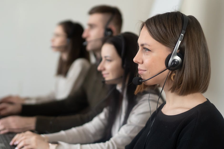 Customer support team working with headsets in a modern office setting.
