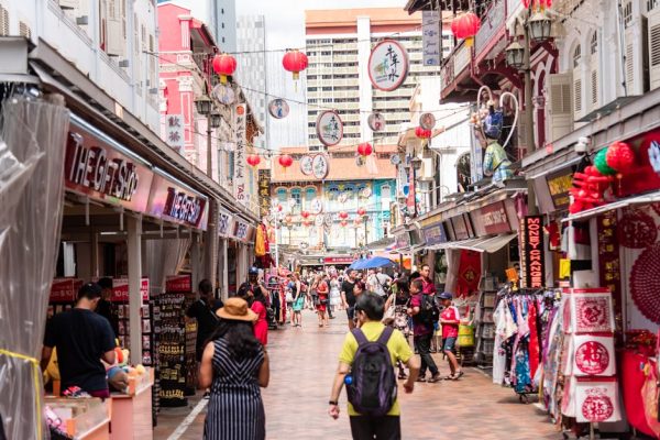 Bustling street market in Singapore's Chinatown featuring shops, people, and Chinese lanterns.