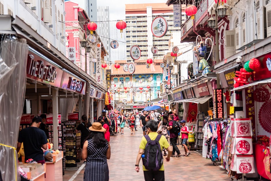 Bustling street market in Singapore's Chinatown featuring shops, people, and Chinese lanterns.