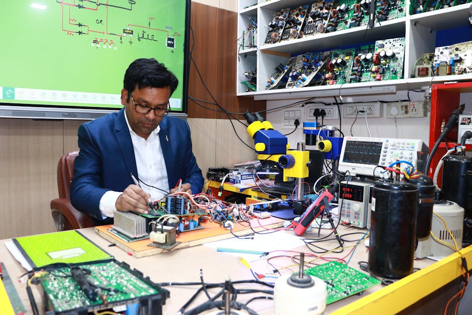 Technician repairing electronics in a lab setting with various tools and circuit boards.