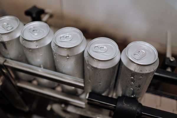 Detail view of aluminum cans with condensation in a manufacturing setting.