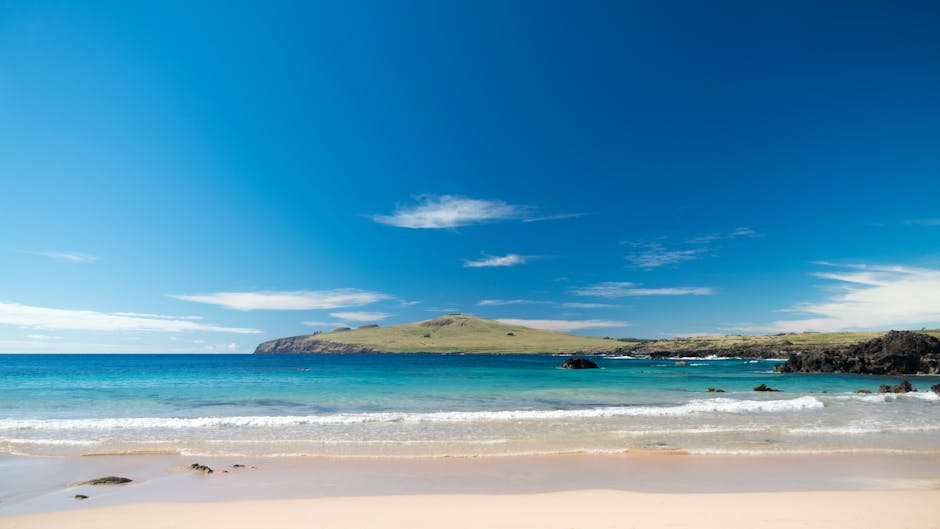 Captivating scene of a pristine beach with clear blue water and distant hills on Easter Island.
