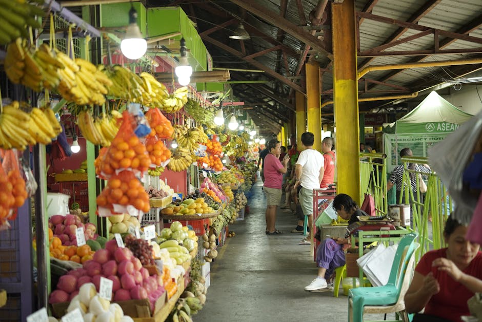 Colorful display of tropical fruits in a bustling Southeast Asian market.