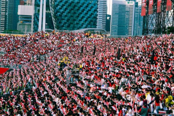 A lively crowd in a stadium during Singapore's National Day Parade.