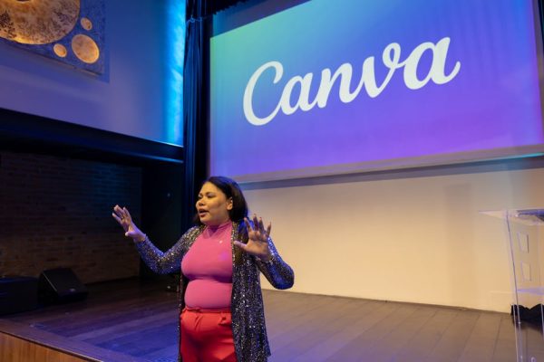 Engaging presentation by a woman in a modern auditorium setting with Canva branding.