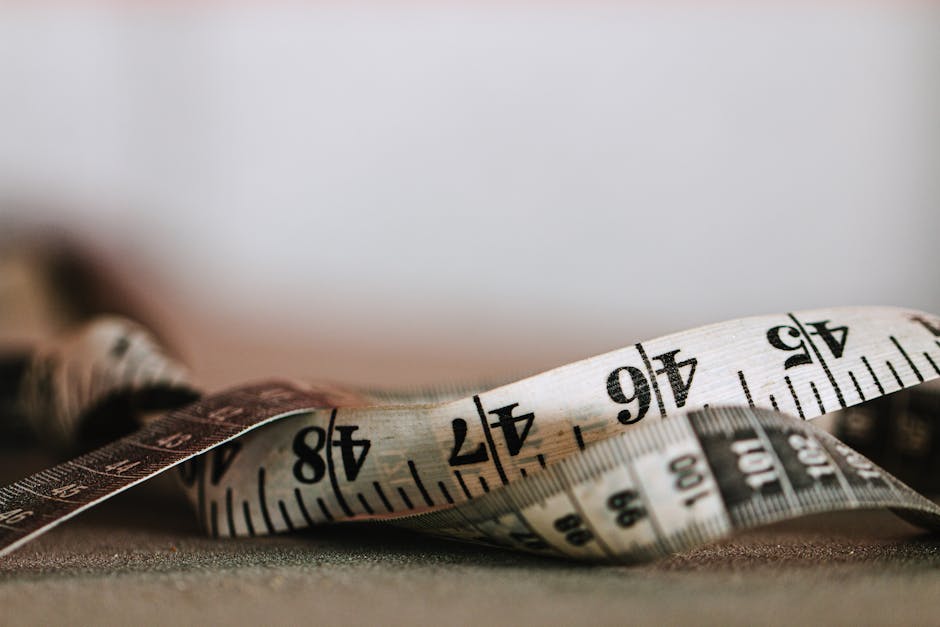 Extreme close-up shot of a coiled measuring tape showing numbers in inches and centimeters.