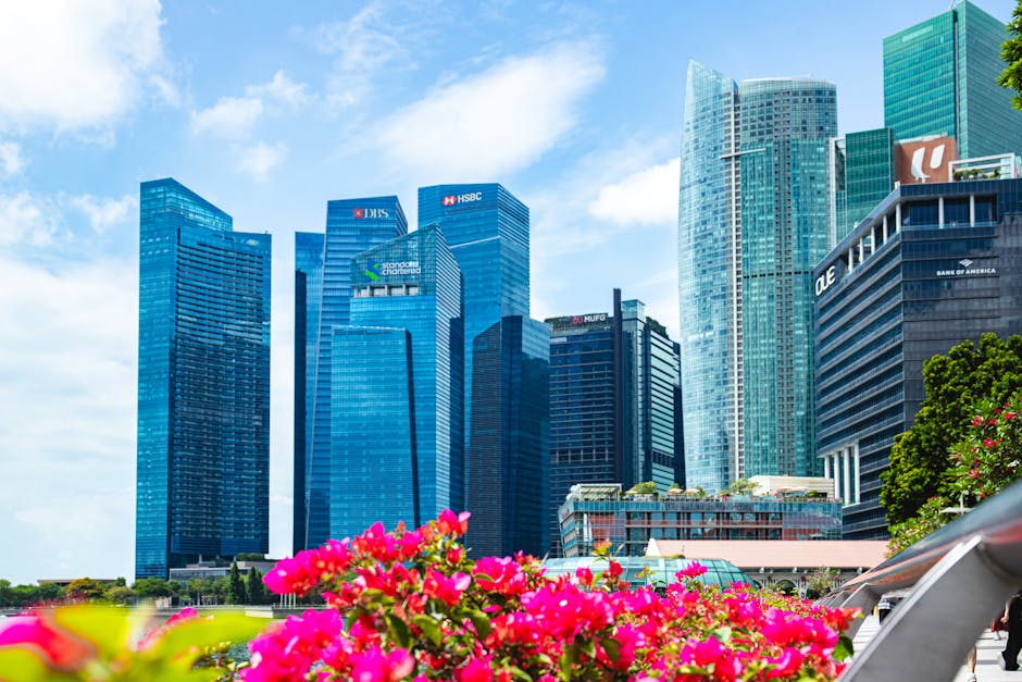 Vibrant skyscrapers in Singapore's Marina Bay with colorful flowers foreground.