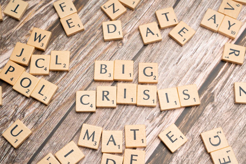 Wooden tiles forming the words 'Big Crisis' on a wooden background.