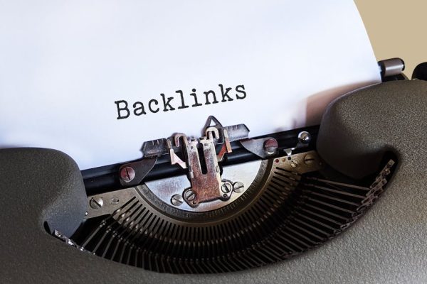 Close-up of a vintage typewriter printing the word 'Backlinks,' emphasizing content and SEO concepts.