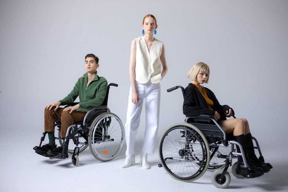 Diverse group showcasing inclusive fashion with wheelchairs in a studio setting.