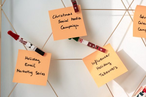 Sticky notes with holiday marketing ideas for Christmas social media and email campaigns.