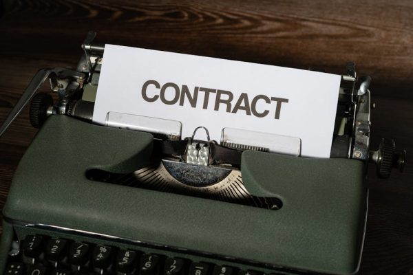 Close-up of a vintage typewriter with a paper labeled 'Contract', evoking a retro office theme.