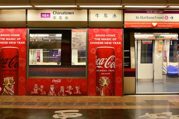 Chinatown MRT adorned with festive Coca-Cola ads for Chinese New Year in Singapore.