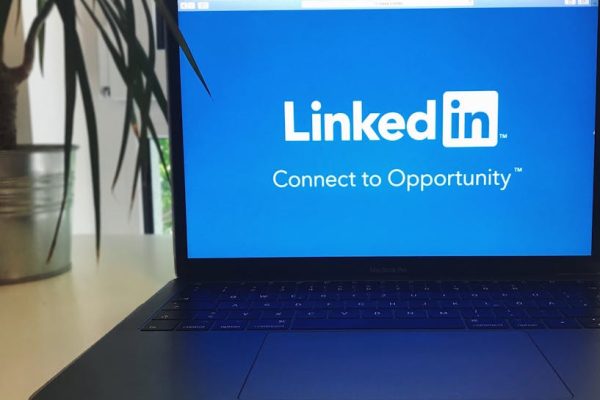 A laptop screen displaying the LinkedIn logo with the text 'Connect to Opportunity'.