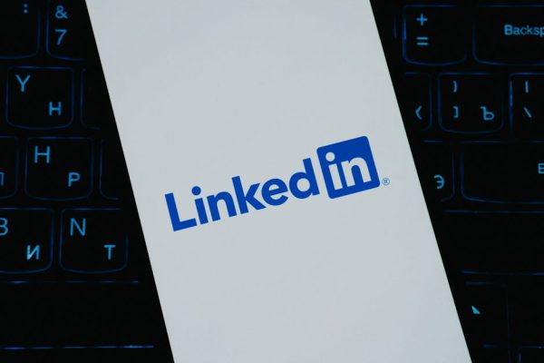 Close-up of LinkedIn logo on smartphone screen, with keyboard background.