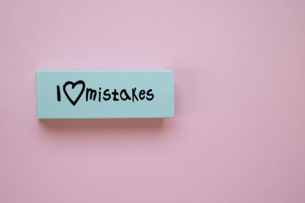 Minimalist eraser with 'I Love Mistakes' message on pink background, school stationery.