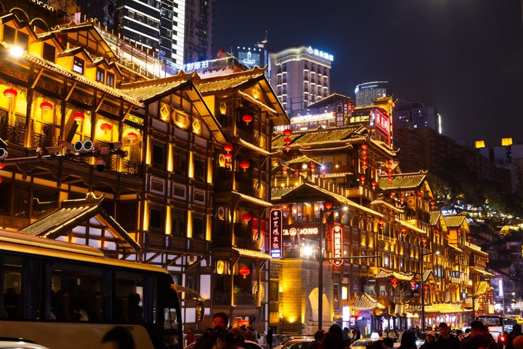 Traditional buildings illuminated at night in a bustling city.