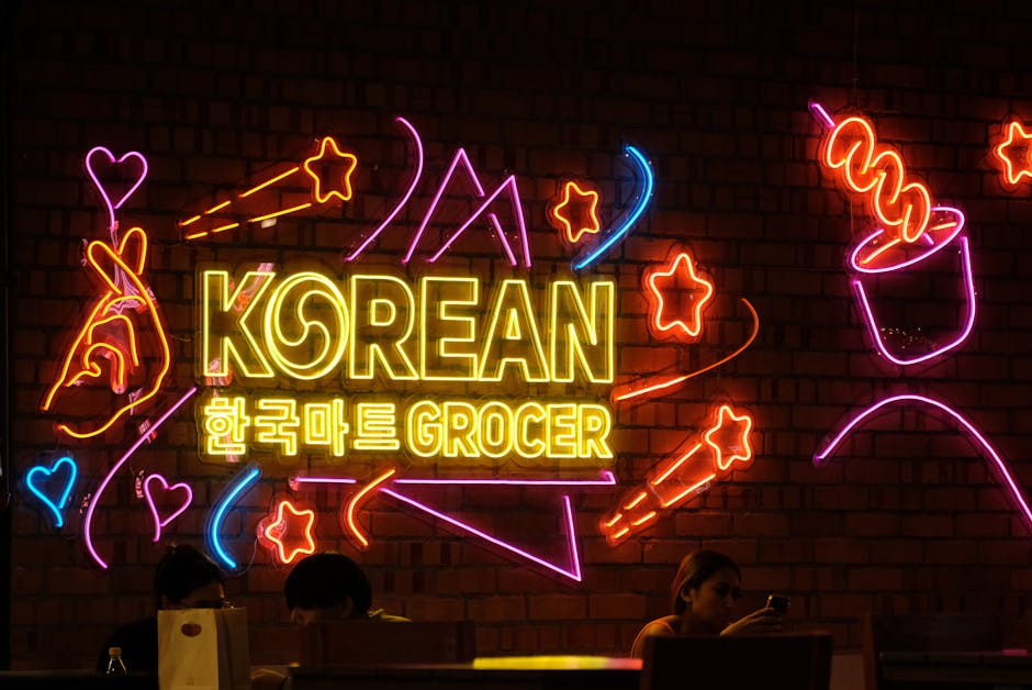 Colorful neon sign with Korean text in a dimly lit shop, highlighting a vibrant urban culture.
