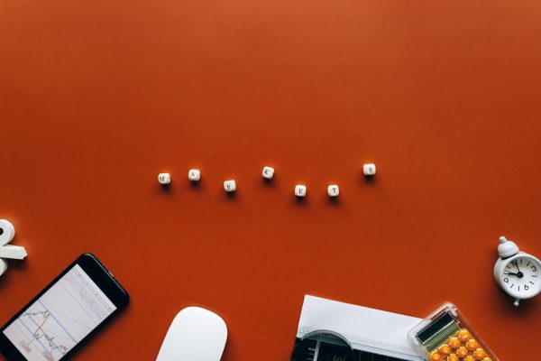 Creative still life with financial tools and the word 'MARKETS' on an orange background.