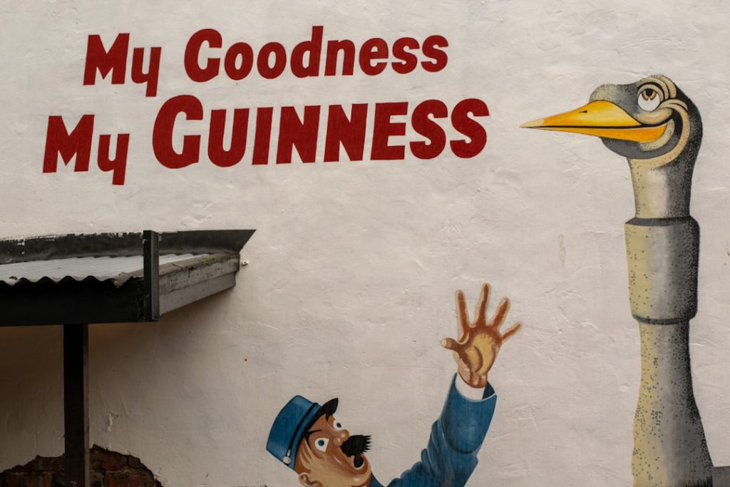 Man reaching for a goose statue with text.