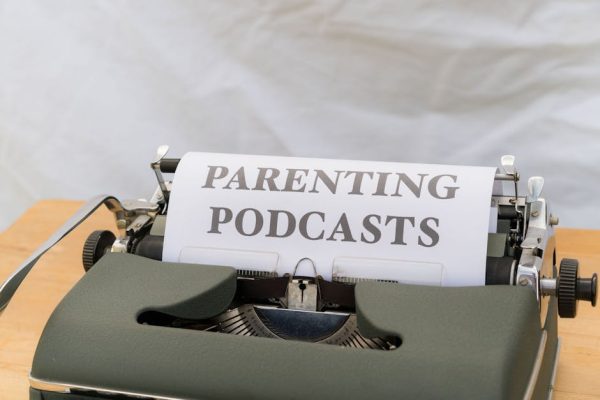 A classic typewriter with a sheet labeled 'Parenting Podcasts' set against a neutral background.