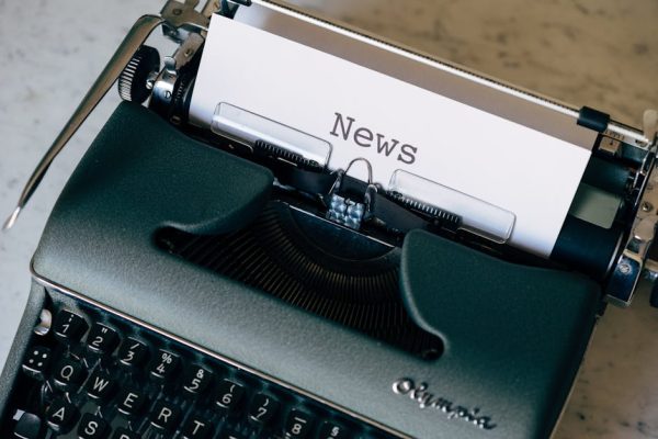 A vintage typewriter with a paper titled 'News', symbolizing journalism and communication.