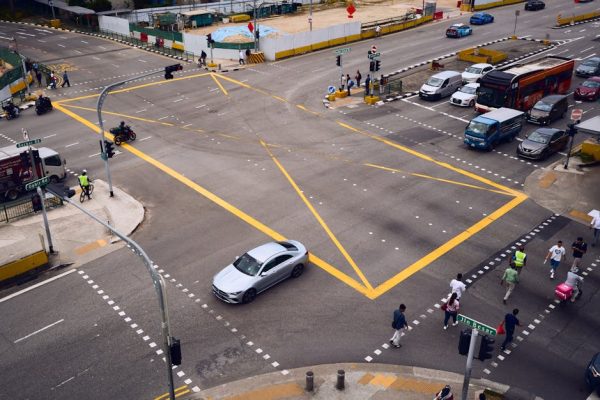 An aerial view of a bustling urban intersection with vehicles and people crossing.